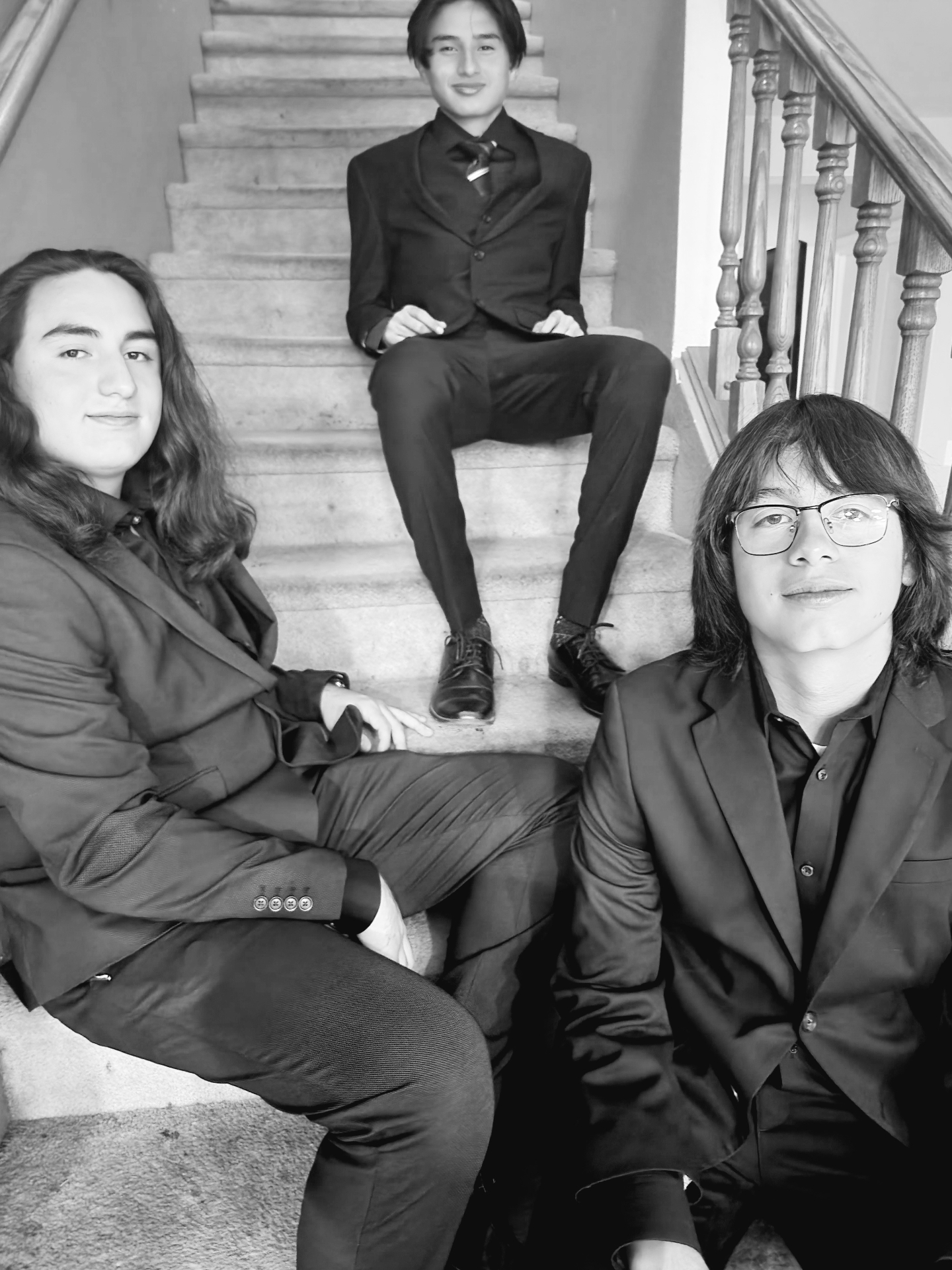 Cruz's sons dressed in suits on the staircase