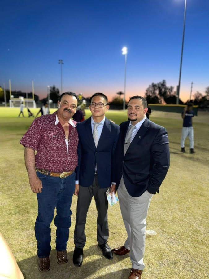 Cruz with his father and son at a ballpark at sunset